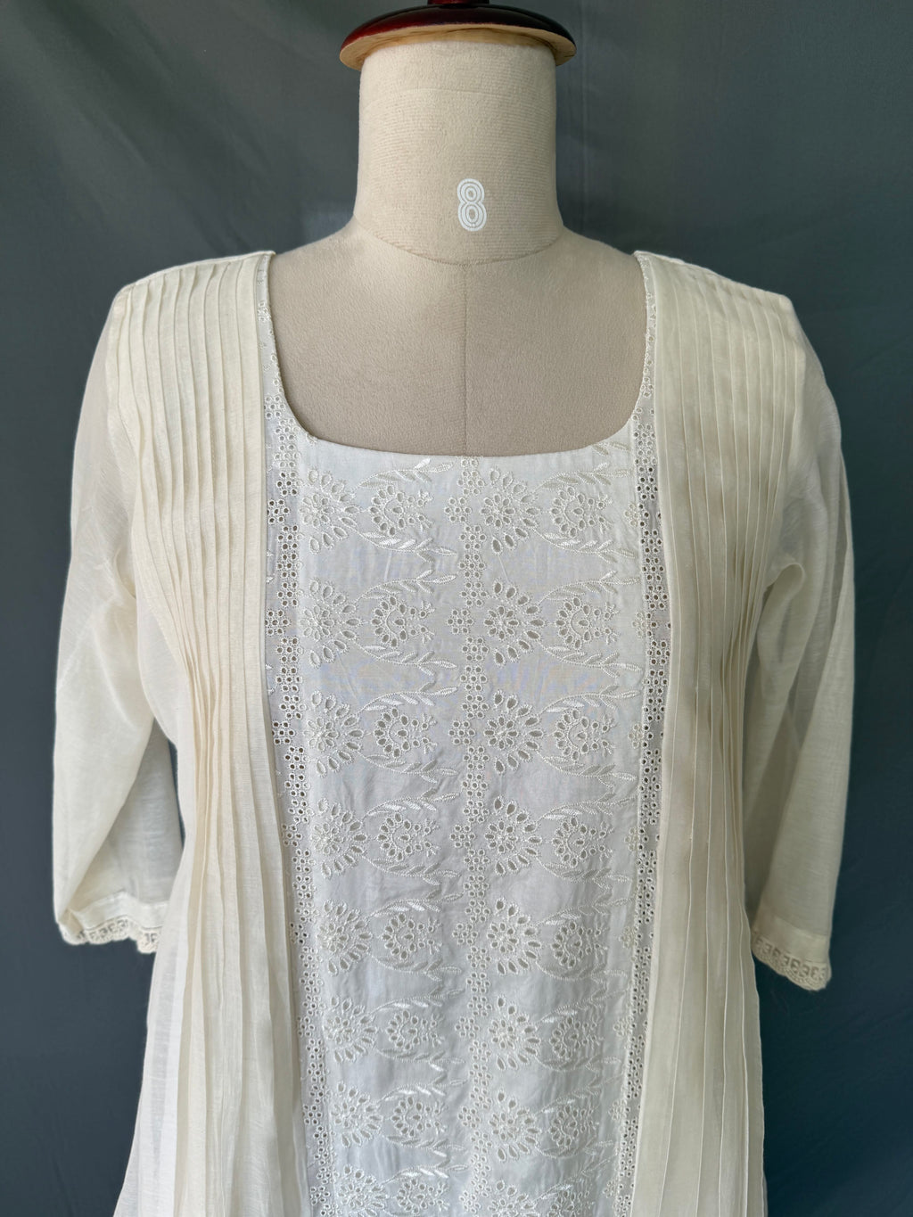 Ivory Zoya White Glass Chanderi Dress with floral embroidery and pleated detailing for festive wear close up view